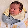 newborn, baby, sleeping, blanket, mittens, bib, teddy_bear, cozy, infant, cute, face, resting, soft, child, wearing, warm, comfort, indoor, portrait, peaceful