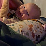 Bailey joined the competition — help win amazing prizes! baby, blanket, pillow, smile, infant, cute, face, indoors, pattern, animal_print, rainbow, child, cozy, soft, lying_down, warm, comfort, head, happy, young