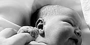 Bailey is registered to the contest to win money with this photo: baby, newborn, infant, black_and_white, smiling, hand, finger, skin, soft, fabric, close_up, portrait, cute, sleeping, child, tender, peaceful, person, human, love