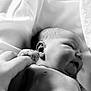 baby, newborn, infant, black_and_white, smiling, hand, finger, skin, soft, fabric, close_up, portrait, cute, sleeping, child, tender, peaceful, person, human, love