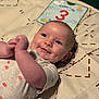 Bailey is registered to the contest to win money with this photo: baby, smiling, infant, blue_eyes, play_mat, milestone_card, dimples, cute, lying_down, patterned_mat, clothing, onesie, hand, face, head, skin, person, young_child, happy, indoors