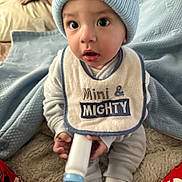 Kayden joined the competition — help win amazing prizes! baby, child, infant, blue_hat, bib, bottle, blanket, cozy, indoors, cute, wide_eyes, soft_toys, sitting, clothing, warm, person, sleepwear, floor, expression, portrait