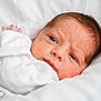 newborn, baby, infant, face, hand, white_blanket, curious_expression, soft_lighting, closeup, portrait, sleepwear, skin, head, lying_down, indoors, young_child, person, cute, cozy, sleep