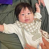 Monako is registered to the contest to win money with this photo: baby, infant, child, person, hand, blanket, clothing, cute, smile, face, hair, toddler, fabric, pattern, checkered, bear, comfort, cozy, indoor, holding