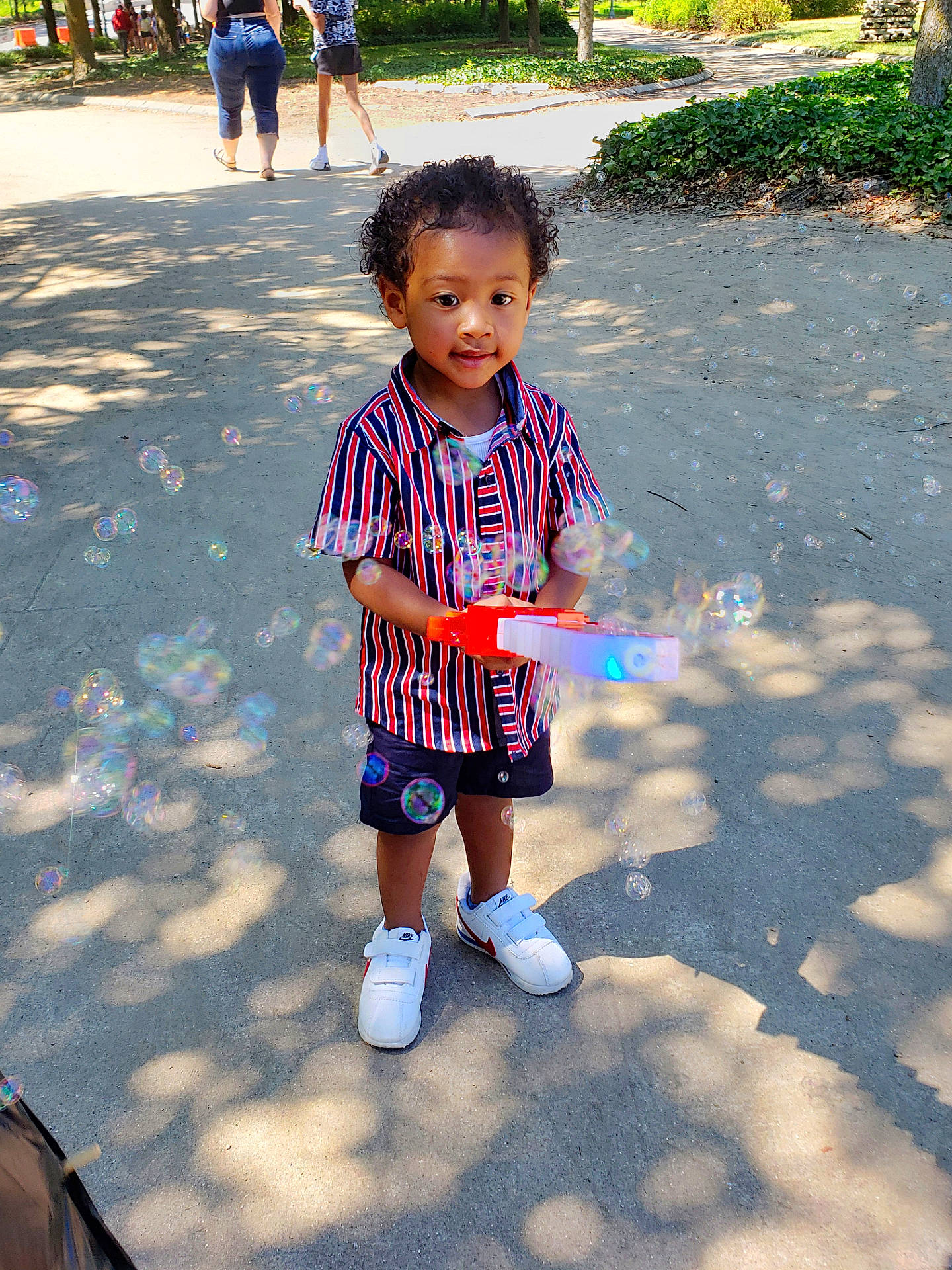 Lennox is registered to the contest to win money with this photo: asphalt, baby_toddler_clothing, child, electric_blue, fun, grass, happy, leisure, pedestrian, person, plant, play, recreation, road, sleeve, snapshot, street, summer, t_shirt, toddler