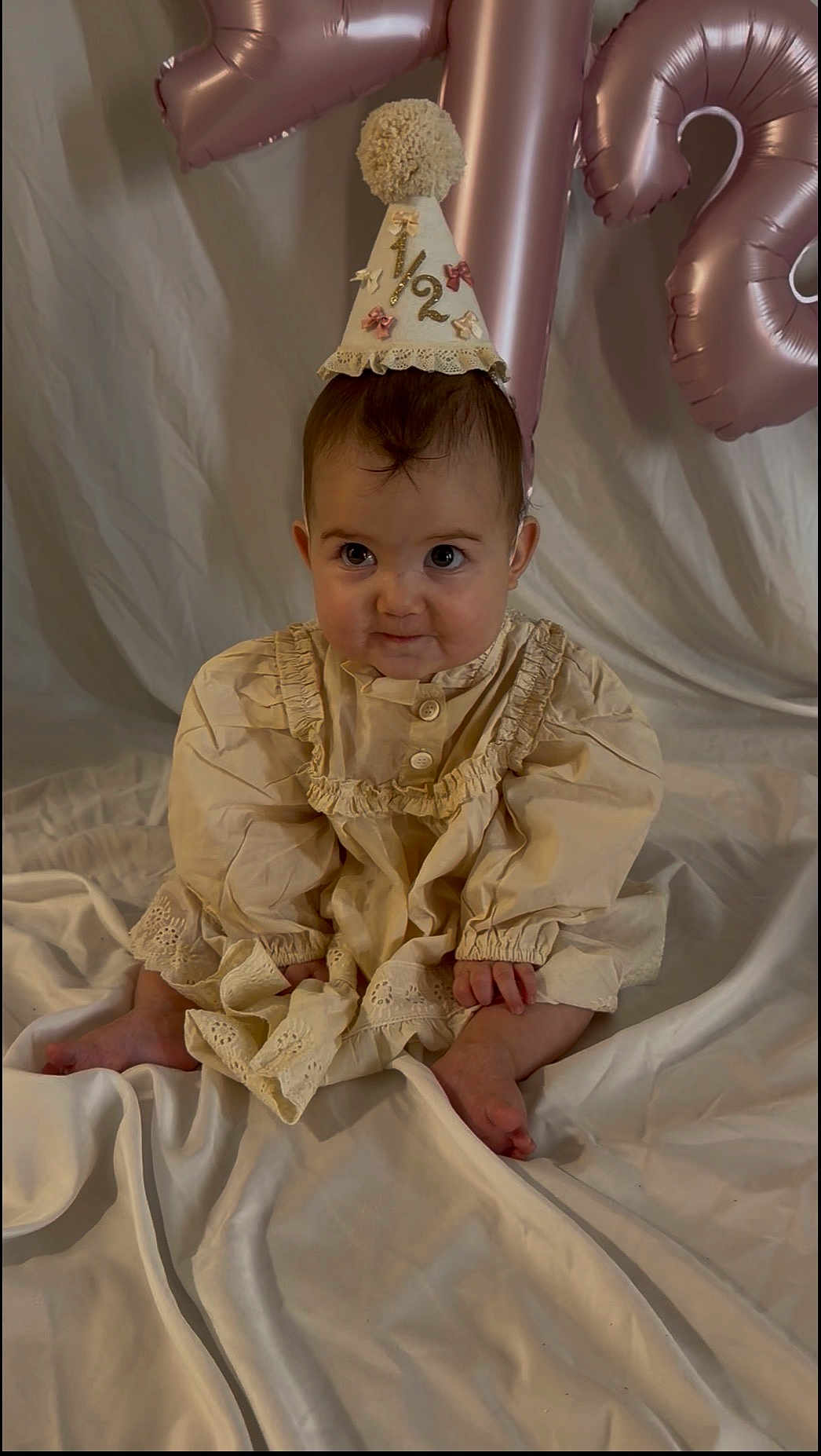 Lennen joined the competition — help win amazing prizes! baby, balloons, birthday, celebration, child, cream_dress, cute, decorations, festive, frills, half_birthday, indoor, infant, number_balloons, party_hat, portrait, sitting, smiling, soft_fabric, young_child