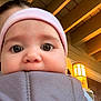 Lennen is registered to the contest to win money with this photo: baby, babybjorn, candid, carrier, child, close_up, curious, expression, eyes, face, headband, indoor, infant, lighting, person, pink, porch_light, soft, warm_light, wooden_beams