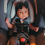 Zayla is registered to the contest to win money with this photo: baby, baby_clothes, black_bow, car_safety, car_seat, child, clothing, cute, footwear, headband, indoors, infant, person, portrait, safety, seat, seatbelt, socks, striped_shirt, young_child