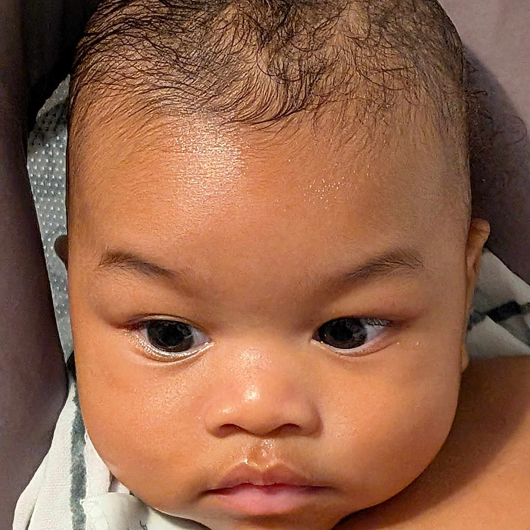 Link is registered to the contest to win money with this photo: baby, child, close_up, curly_hair, cute, expression, eyes, face, gaze, head, indoors, infant, natural_light, newborn, person, portrait, shoulder, skin, towel, young