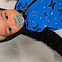 baby, infant, pacifier, hat, hoodie, blue_clothing, black_clothing, knit_hat, face, eyes, hand, lying_down, indoors, child, cute, young, portrait, warm_clothing, expression, baby_fashion