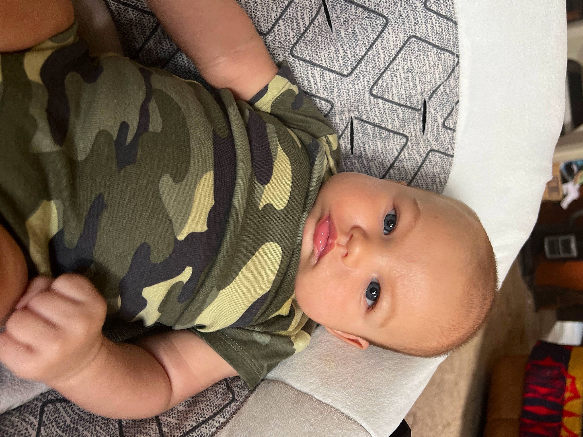 Rip is registered to the contest to win money with this photo: arm, baby, baby_products, baby_toddler_clothing, cheek, child, comfort, eyelash, finger, gesture, hand, military_camouflage, nail, pattern, person, sitting, skin, sleeve, thumb, toddler