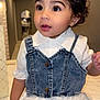 toddler, child, girl, denim_vest, white_dress, curly_hair, hair_bow, indoor, portrait, cute, face, eyes, fashion, clothing, person, baby, expression, curiosity, furniture, mirror