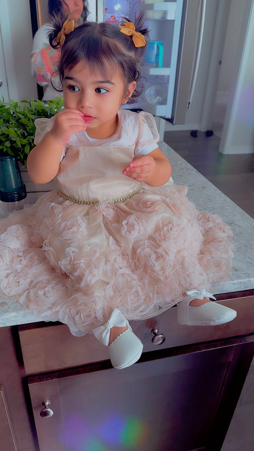 Sanaya joined the competition — help win amazing prizes! baby, bows, cabinet, child, countertop, curly_hair, cute, dress, floor, furniture, girl, hair, indoor, kitchen, pensive, person, plant, portrait, white_shoes, young_child