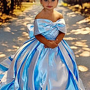 Jailyne is registered to the contest to win money with this photo: child, princess, dress, blue_dress, tiara, outdoor, path, trees, sunlight, portrait, young_girl, formal_wear, nature, smile, posing, fashion, elegant, celebration, cute, happy