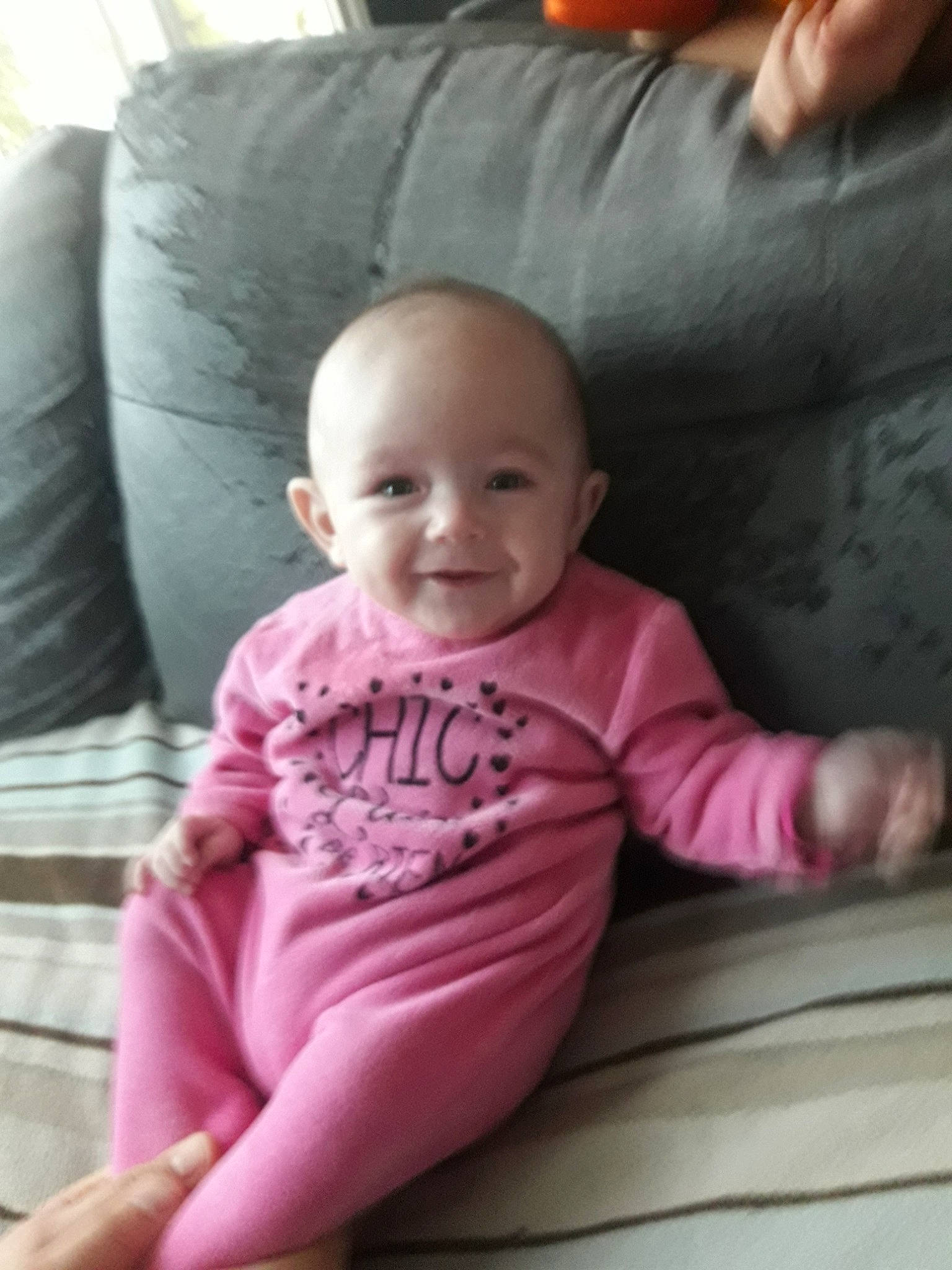 Alyson participe au concours pour gagner de l'argent avec cette photo : arm, baby, cheek, child, eye, face, finger, hand, head, mouth, person, pink, sitting, skin, smile, toddler