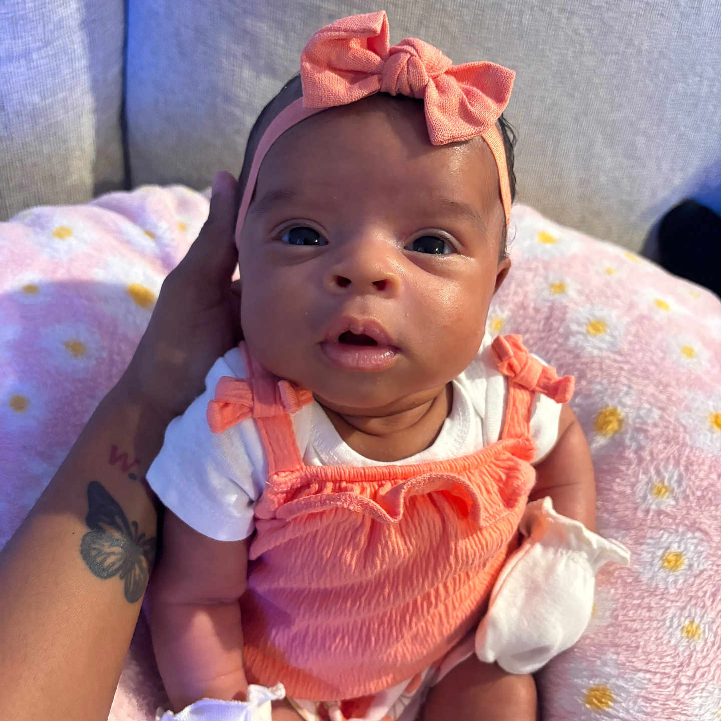 Ahmari joined the competition — help win amazing prizes! baby, blanket, bow, child, clothing, cute, hand, headband, indoor, infant, mittens, newborn, orange, person, pink, portrait, sitting, soft, tattoo, white