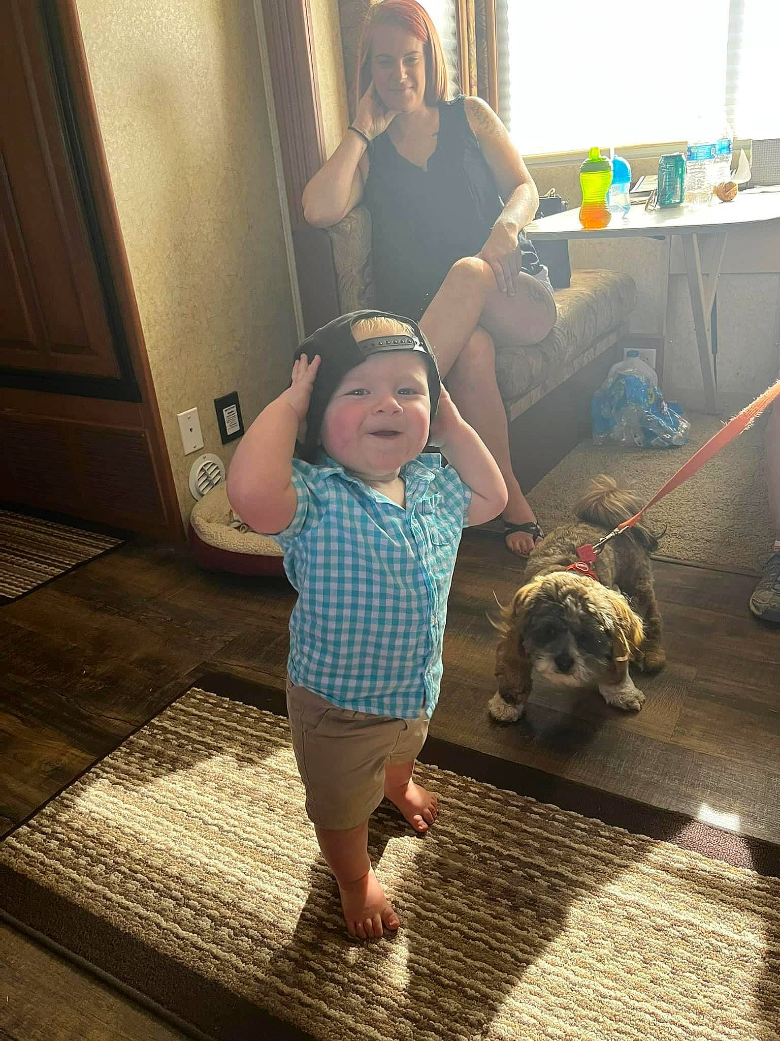 Everett is registered to the contest to win money with this photo: baby, baby_toddler_clothing, barefoot, companion_dog, face, floor, flooring, foot, fun, happy, headwear, human_leg, joy, leg, mammal, person, play, shoulder, t_shirt, tail