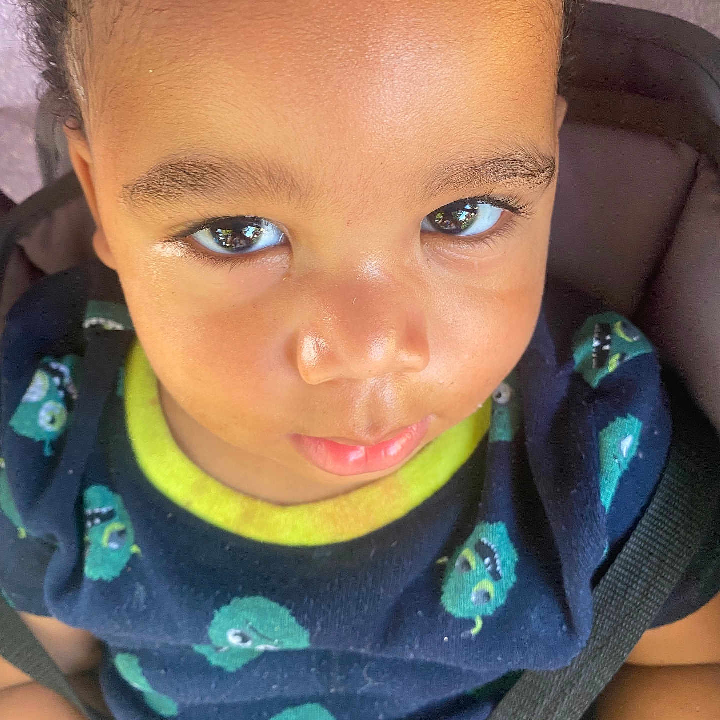Zion is registered to the contest to win money with this photo: baby, car_seat, casual, child, closeup, clothing, curious, cute, expression, eyes, face, indoor, person, portrait, seatbelt, shirt, sitting, smile, toddler, young