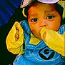 M'Kai is registered to the contest to win money with this photo: baby, child, costume, minion, blue_clothing, yellow_gloves, face, eyes, sitting, cute, infant, portrait, indoor, cute_expression, young_child, cozy, colorful, funny_outfit, hands, looking_at_camera