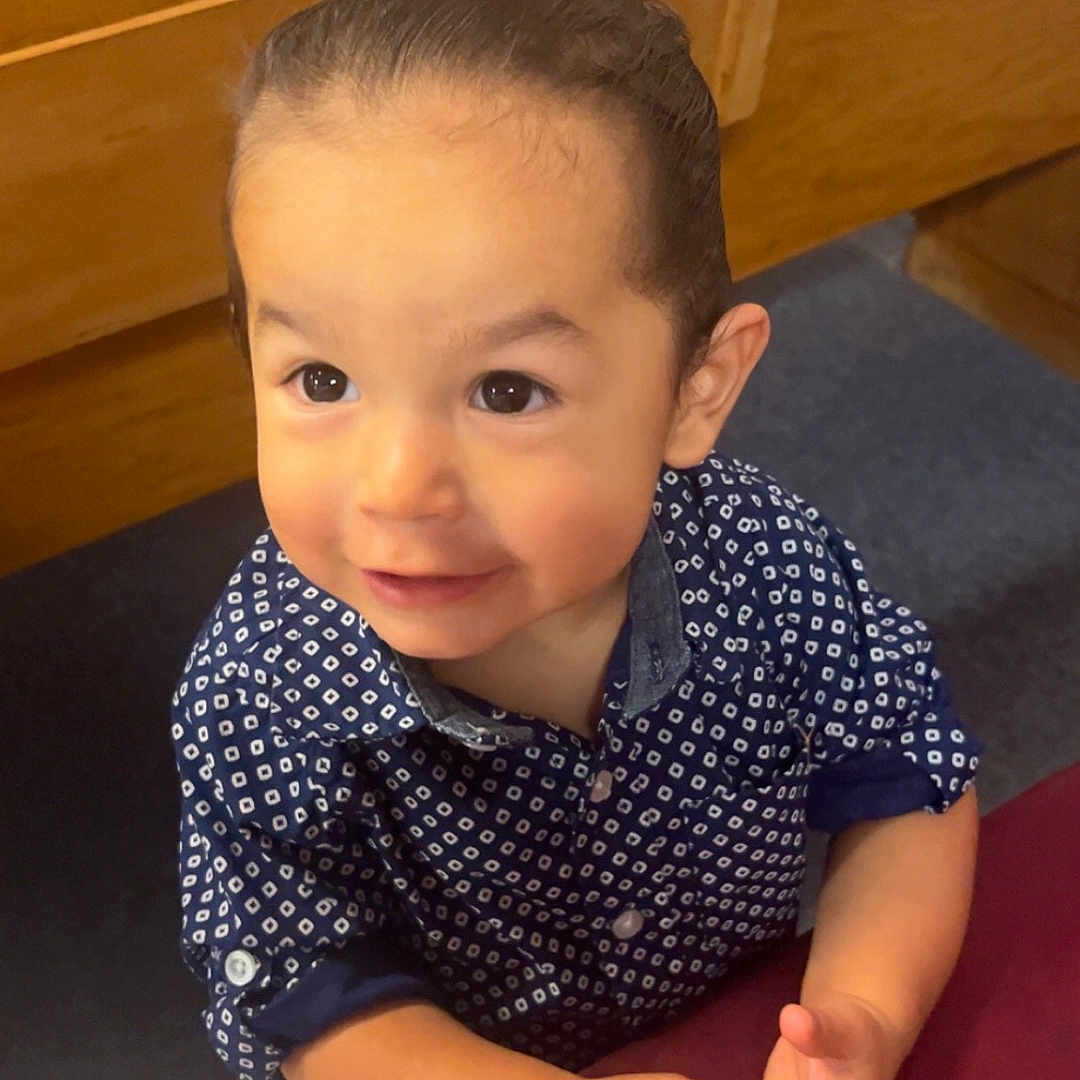 Matthew is registered to the contest to win money with this photo: baby, bodypart, clothing, dress, face, finger, furniture, hand, happy, hardwood, head, pattern, person, photography, plywood, portrait, shirt, sitting, smile, wood