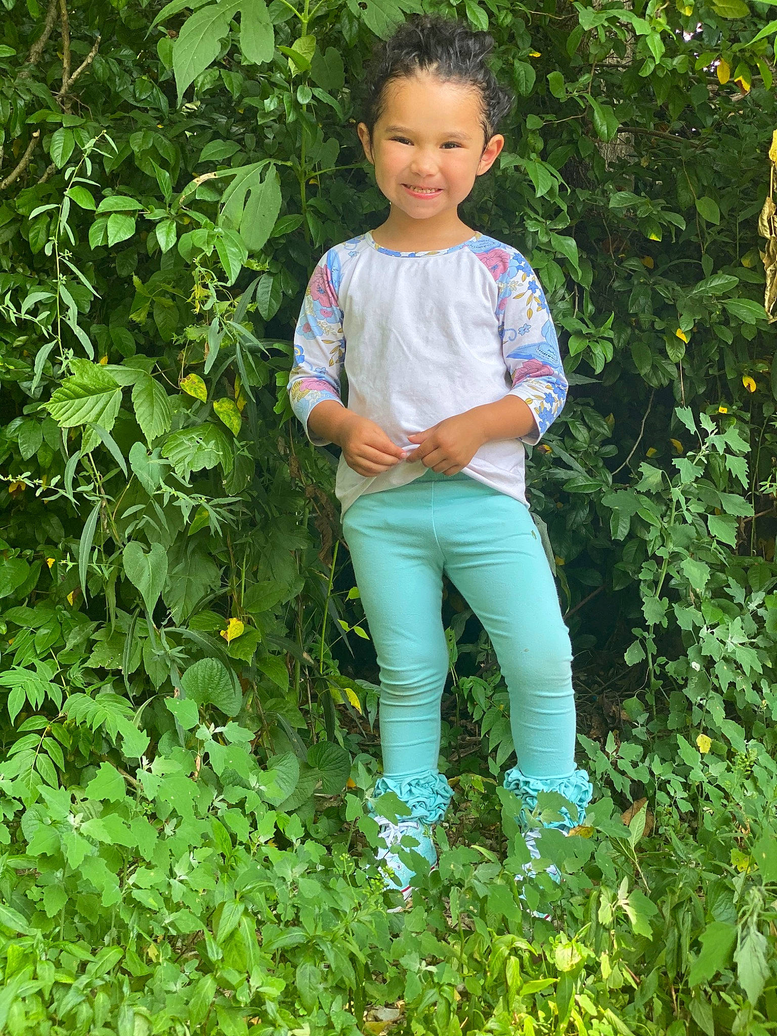 Lorena is registered to the contest to win money with this photo: baby_toddler_clothing, child, clothing, eye, face, garden, grass, green, groundcover, happy, head, joy, people_in_nature, person, plant, shrub, sitting, sleeve, smile, t_shirt