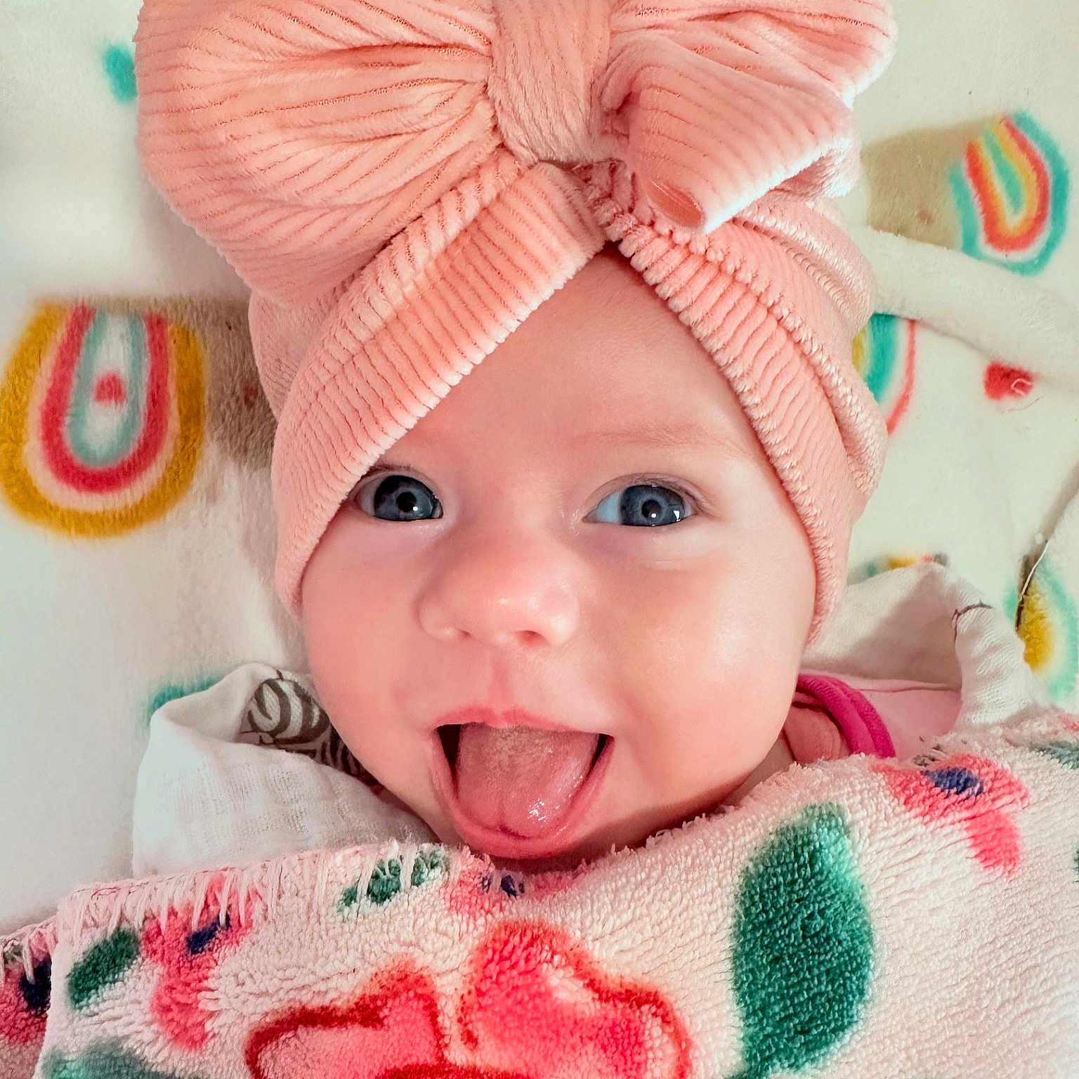 Hailey is registered to the contest to win money with this photo: baby, babylaughing, blanket, bodypart, bonnet, cap, clothing, doll, face, happy, hat, head, mouth, newborn, person, photography, portrait, smile, tongue, toy