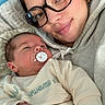 Alessyo a rejoint le concours — aidez-le/la à gagner de superbes lots ! baby, newborn, woman, glasses, pacifier, hugging, indoor, soft_lighting, cozy, blanket, couch, portrait, smiling, casual_clothing, person, face, hand, family, togetherness, love