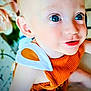 baby, child, blue_eyes, close_up, orange_clothing, white_clothing_detail, infant, face, portrait, cute, soft_skin, indoor, young_child, smiling, happy, person, toddler, eyelashes, cheeks, bright_eyes