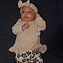 baby, child, cozy, curious, cute, dark_background, fashion, floral_pants, headband, indoor, infant, infant_fashion, lying_down, patterned_clothing, portrait, small_hands, sock, soft_fabric, sweater, young_child