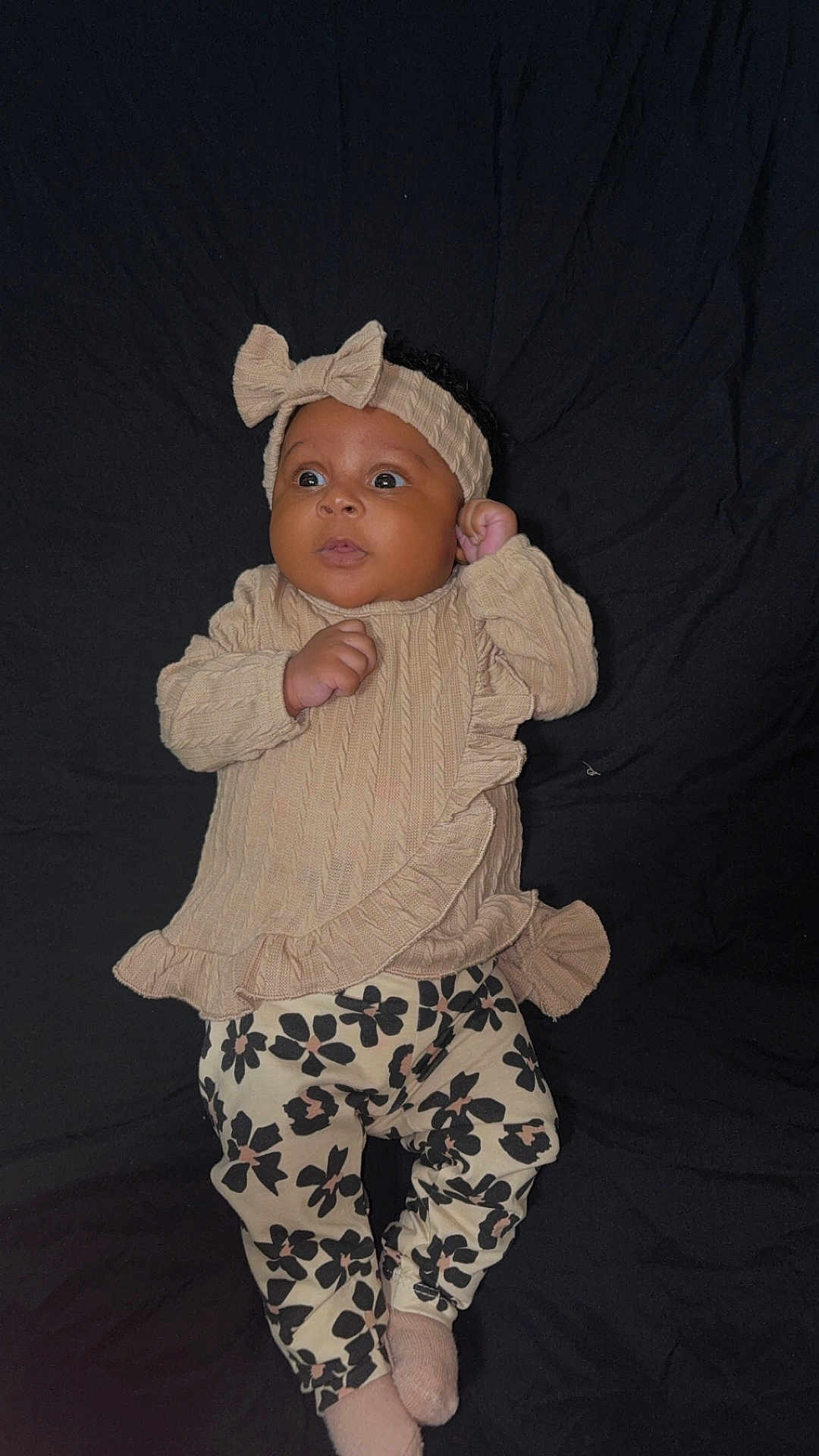 Keshaunda Coe joined the competition — help win amazing prizes! baby, child, cozy, curious, cute, dark_background, fashion, floral_pants, headband, indoor, infant, infant_fashion, lying_down, patterned_clothing, portrait, small_hands, sock, soft_fabric, sweater, young_child
