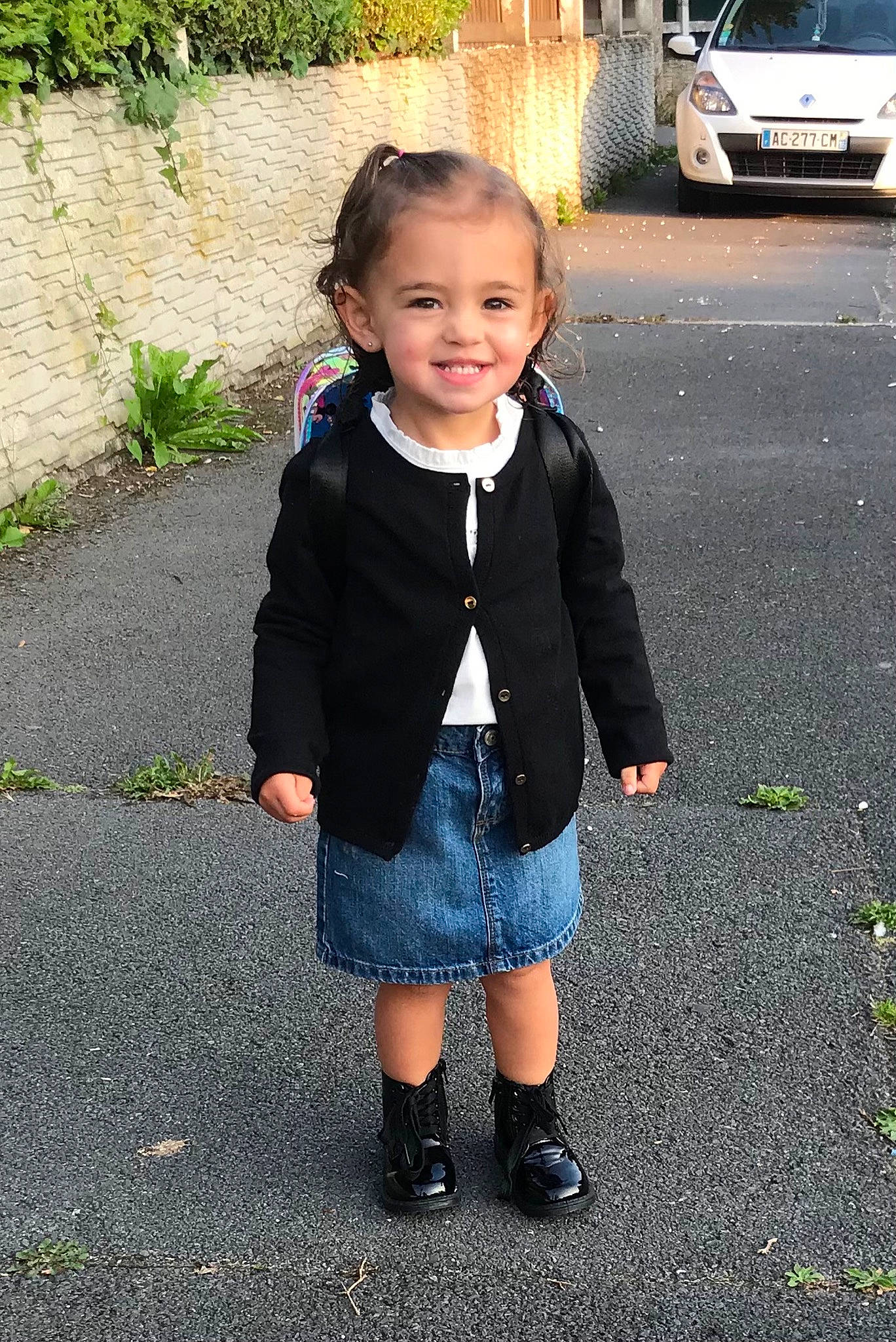 Nélia participe au concours pour gagner de l'argent avec cette photo : asphalt, automotive_lighting, baby_toddler_clothing, car, clothing, denim, electric_blue, face, family_car, grass, joy, pattern, person, plant, road_surface, sidewalk, sleeve, smile, t_shirt, toddler