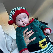 Tyanna a rejoint le concours — aidez-le/la à gagner de superbes lots ! baby, child, infant, elf_costume, holiday, festive, hat, red, green, striped, person, indoor, hand, adult, coat, floor, wall, light, portrait, cute