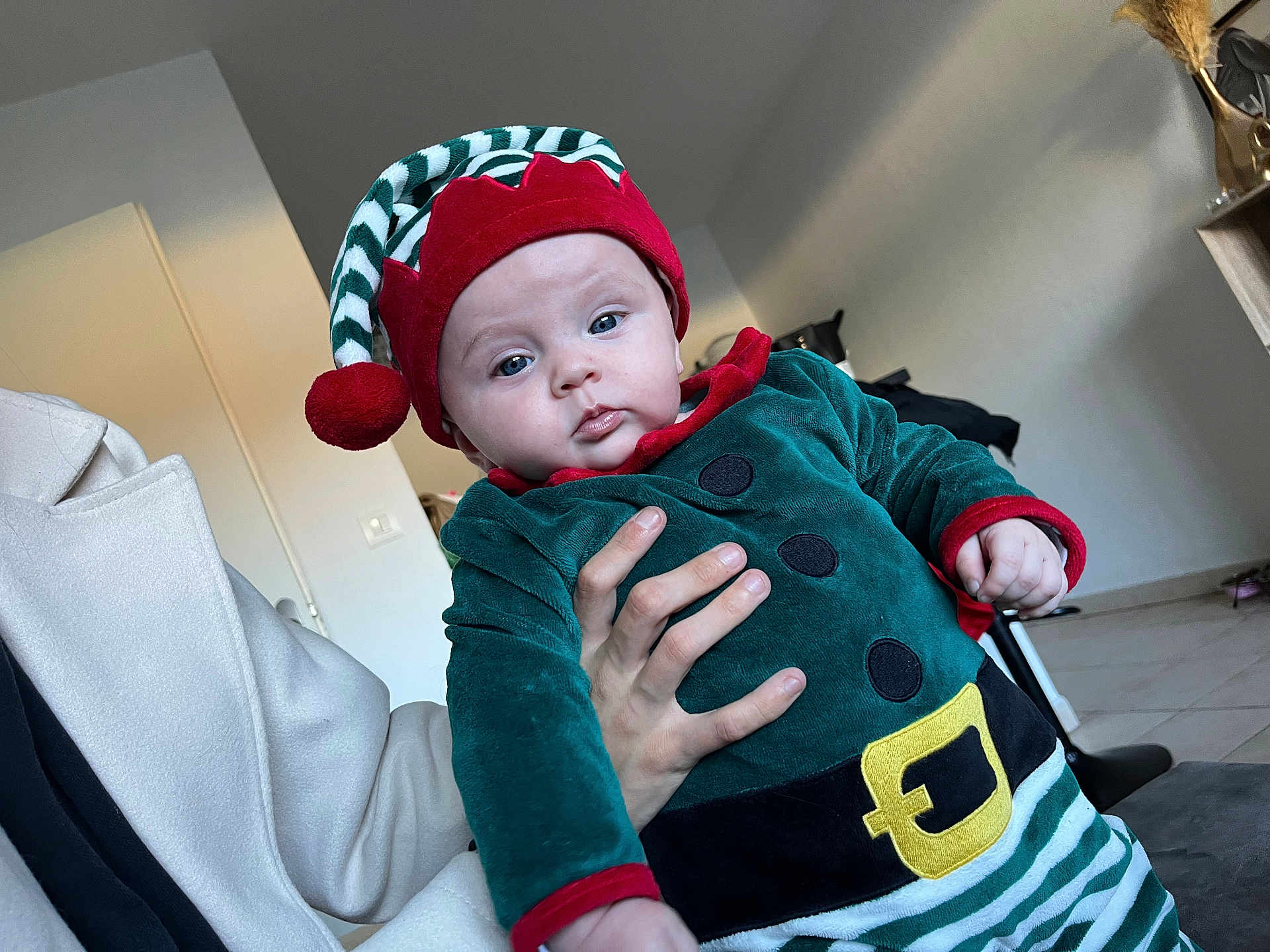 Tyanna a rejoint le concours — aidez-le/la à gagner de superbes lots ! baby, child, infant, elf_costume, holiday, festive, hat, red, green, striped, person, indoor, hand, adult, coat, floor, wall, light, portrait, cute