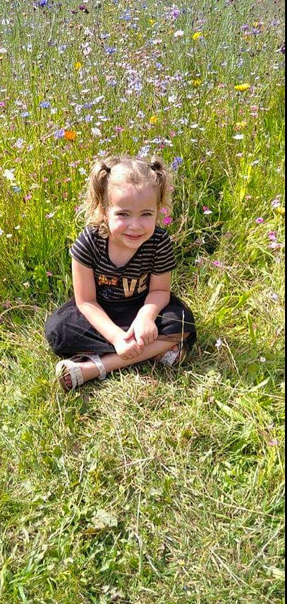 Maëlyne a rejoint le concours — aidez-le/la à gagner de superbes lots ! ecoregion, flower, fun, grass, grass_family, grassland, groundcover, happy, head, joy, lawn, leaf, meadow, people_in_nature, person, plant, prairie, sitting, smile, soil