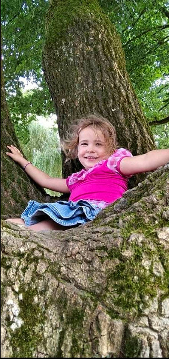 Maëlyne participe au concours pour gagner de l'argent avec cette photo : botany, child, forest, fun, grass, happy, human_body, joy, leaf, leisure, people_in_nature, person, plant, recreation, sitting, smile, terrestrial_plant, toddler, tree, trunk