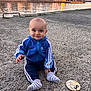 Mathéïs participe au concours pour gagner de l'argent avec cette photo : 8_months, baby, blue_jacket, child, clothing, gravel, happy, houses, infant, milestone_marker, nature, outdoor, person, reflection, sitting, smile, socks, sunset, tracksuit, waterfront