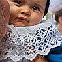 baby, black, child, closeup, clothing, cute, expression, face, hand, headwear, holding, infant, lace, outdoor, person, portrait, skin, soft, texture, white