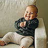 Ezra is registered to the contest to win money with this photo: baby, child, smiling, couch, indoor, knit_pants, sweater, barefoot, face, happy, light, window, relaxing, furniture, portrait, cute, infant, seated, home, cozy