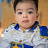 child, toddler, portrait, costume, prince, blue, gold, white_shirt, face, eyes, curly_hair, young_child, cute, fashion, indoor, closeup, expressionless, baby, person, sitting