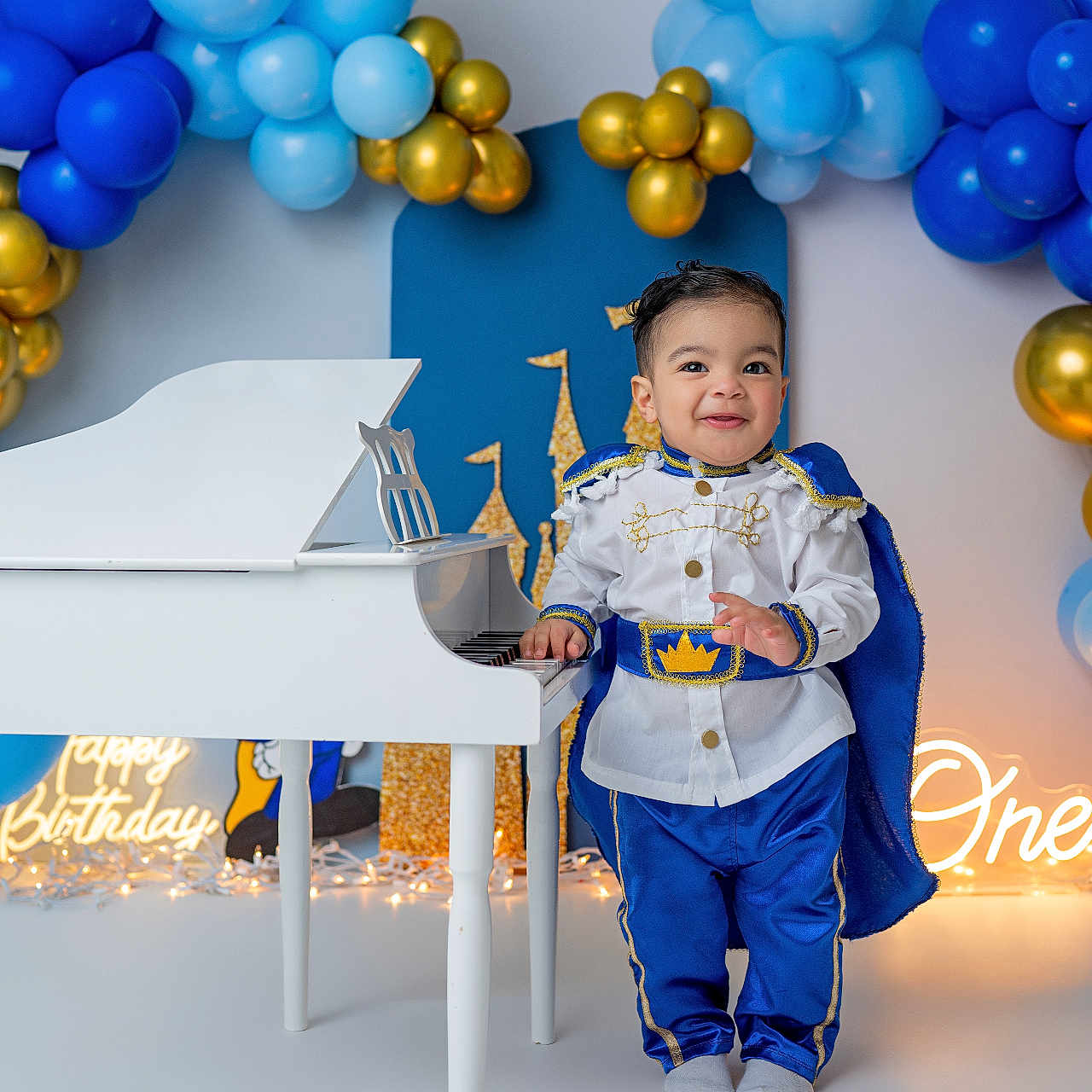 Haisbran is registered to the contest to win money with this photo: toddler, child, boy, birthday, party, costume, prince, blue, gold, balloons, piano, toy, celebration, smile, cape, white, floor, decorations, happy, indoor