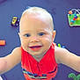 Killian is registered to the contest to win money with this photo: baby, child, smiling, orange_clothing, toy, play_mat, blue_eyes, indoor, cute, happy, infant, barefoot, colorful_toys, closeup, portrait, person, playtime, looking_up, small_toy_car, green_toy