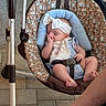 baby, infant, sleeping, baby_swing, headband, bib, cute, peaceful, indoor, carpet, floor_tiles, baby_clothes, patterned_fabric, animal_print, relaxed, person, foot, leg, resting, comfort