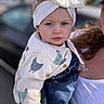 toddler, child, baby, headband, bow, blue_eyes, sweater, chicken_pattern, denim_overalls, person, adult, holding, outdoor, daylight, portrait, close_up, serious_expression, fashion, cute, female
