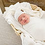newborn, baby, smiling, wrapped, blanket, knit_hat, basket, cozy, soft, white, sleeping, peaceful, infant, cute, resting, fabric, texture, closeup, portrait, indoors