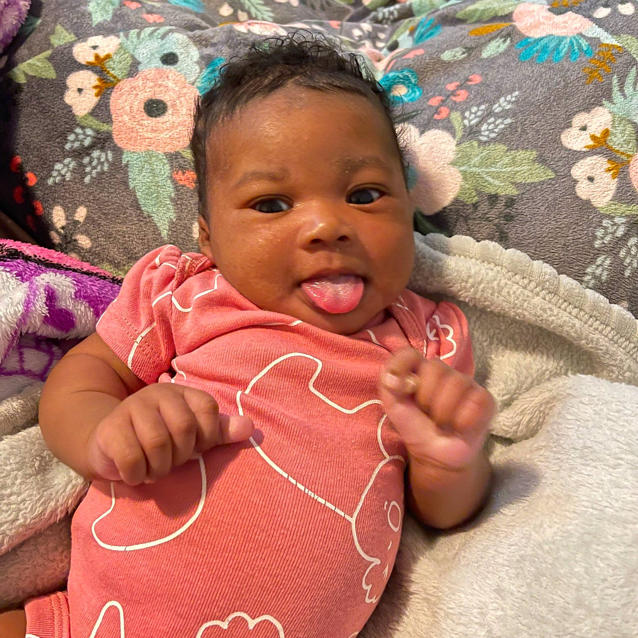 Jaylani joined the competition — help win amazing prizes! baby, baby_toddler_clothing, cheek, child, comfort, finger, gesture, happy, head, human_body, linens, lip, nose, pattern, person, pink, product, skin, smile, textile