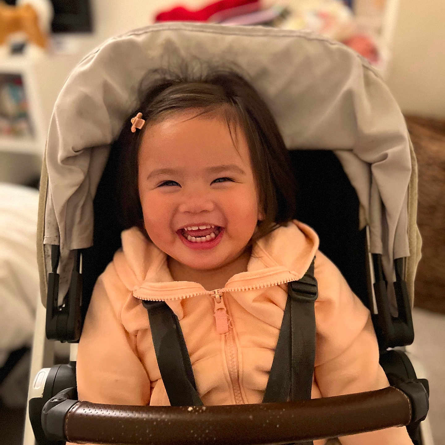 Ellie joined the competition — help win amazing prizes! accessories, baby, babylaughing, bed, bodypart, clothing, coat, face, happy, head, jacket, laughing, mouth, person, photography, portrait, smile, strap, stroller, teeth
