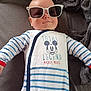 baby, sunglasses, onesie, mickey_mouse, striped_clothing, blanket, infant, child, cute, smiling, face, head, person, lying_down, cozy, indoor, soft_texture, clothing, baby_garment, casual