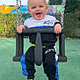 toddler, child, swing, playground, smiling, happy, outdoor, clothing, socks, bear, chains, greenery, fence, colorful, mural, sky, daylight, fun, person, park