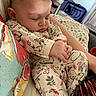 Selena is registered to the contest to win money with this photo: animal_print, arm, baby, child, closeup, cushion, cute, fabric, face, hand, indoor, infant, pajamas, pattern, peaceful, person, relaxation, rest, sleeping, soft_lighting