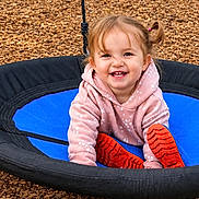 Raelynn joined the competition — help win amazing prizes! backyard, blue_seat, cheerful, child, daylight, girl, grass, happy, outdoor, pink_hoodie, play, playground, portrait, red_boots, sitting, smiling, swing, toddler, trees, wood_chips